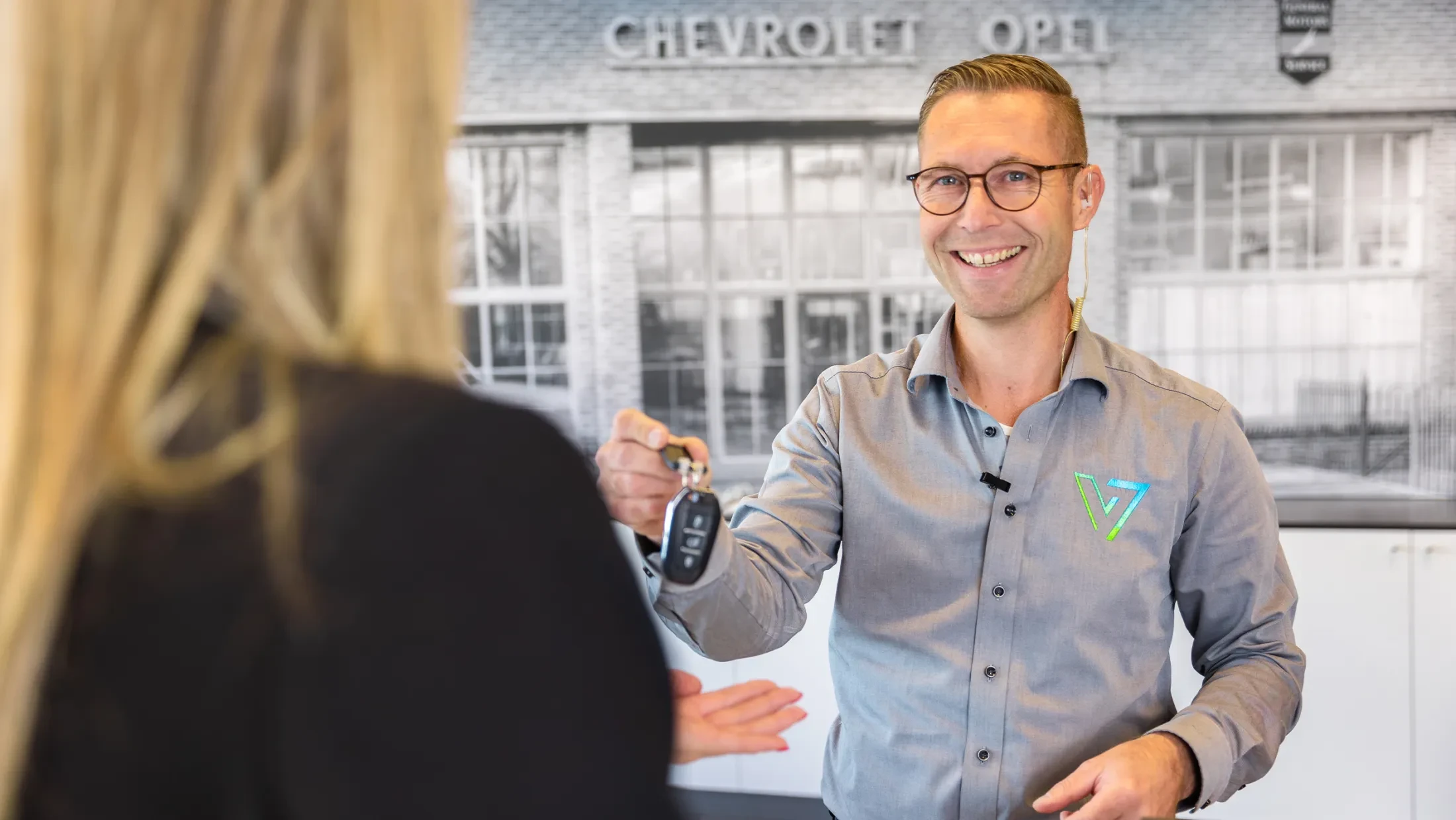 Serviceadviseur geeft autosleutels aan klant