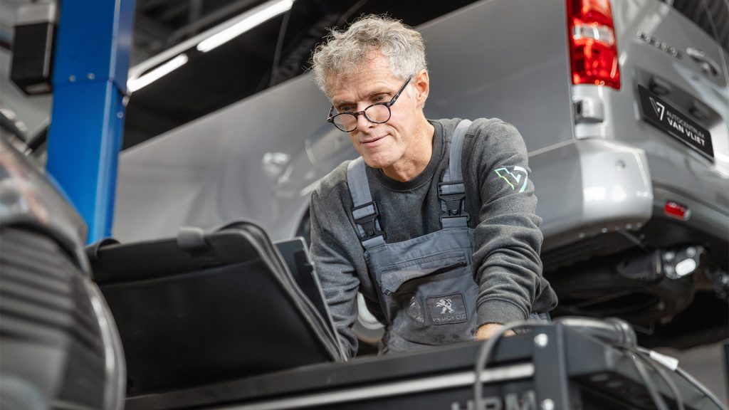 Monteur checkt laptop tijdens onderhoud Fiat Professional bedrijfswagen