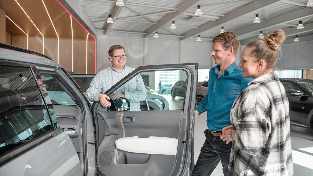 Verkoopadviseur voert een taxatie uit op een auto van een klant