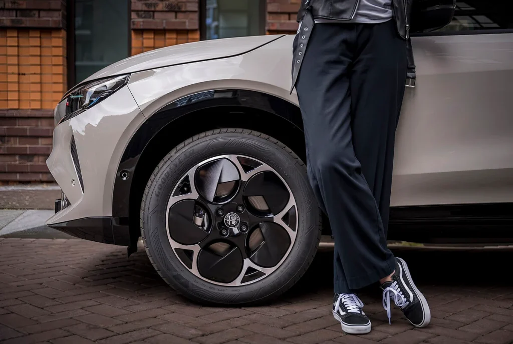 Detail van het voorwiel en de zwarte lichtmetalen velg van de auto.