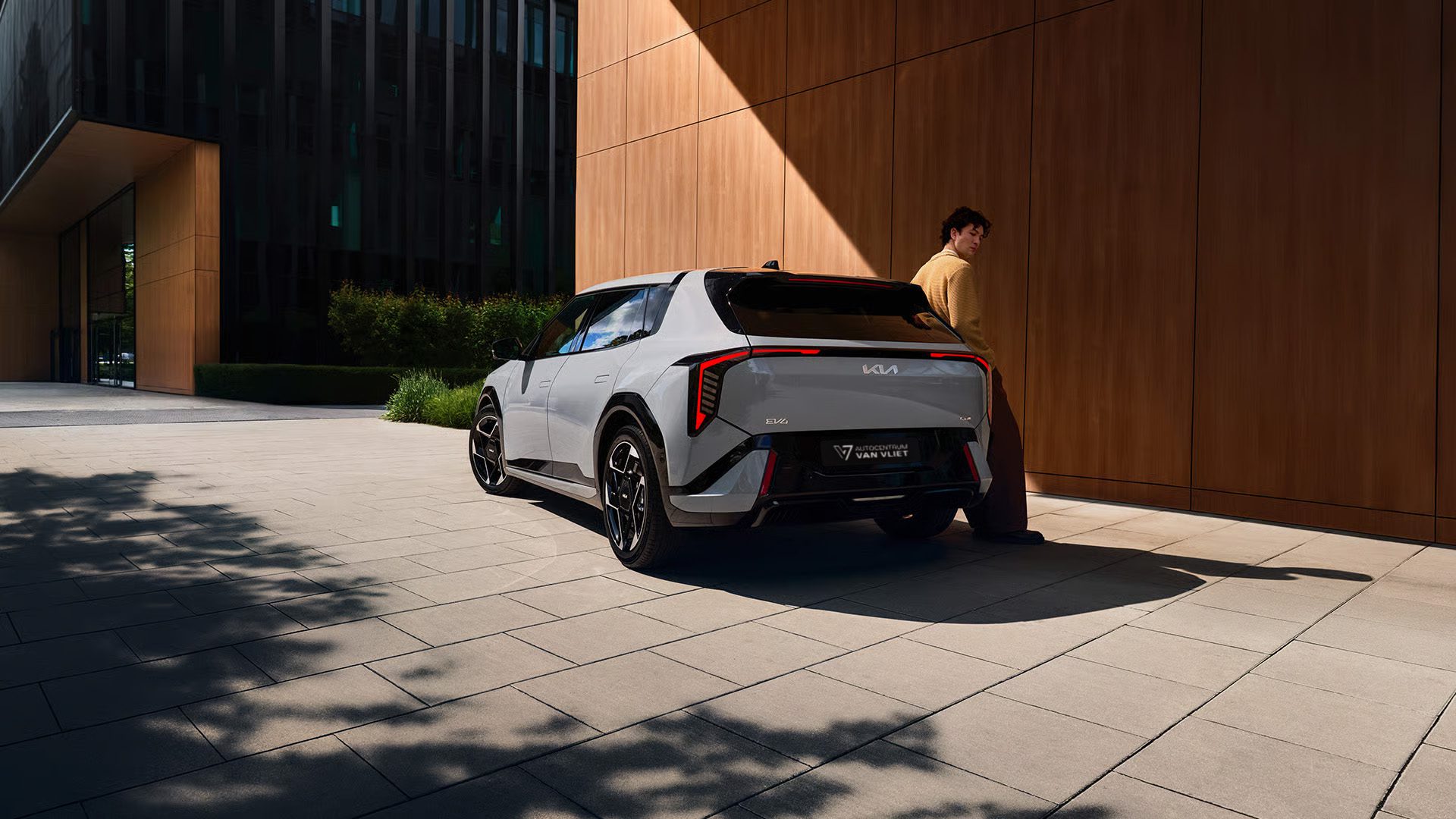 Man staat trots naast zijn nieuwe Kia EV4