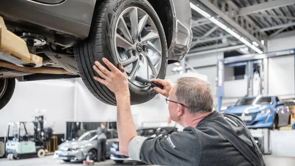 De monteur controleert de remmen van een auto als onderdeel van een apk keuring