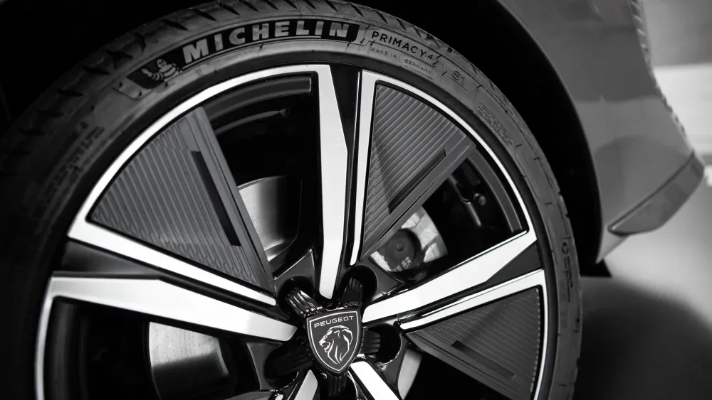 Een autoband en een velg van het merk Peugeot