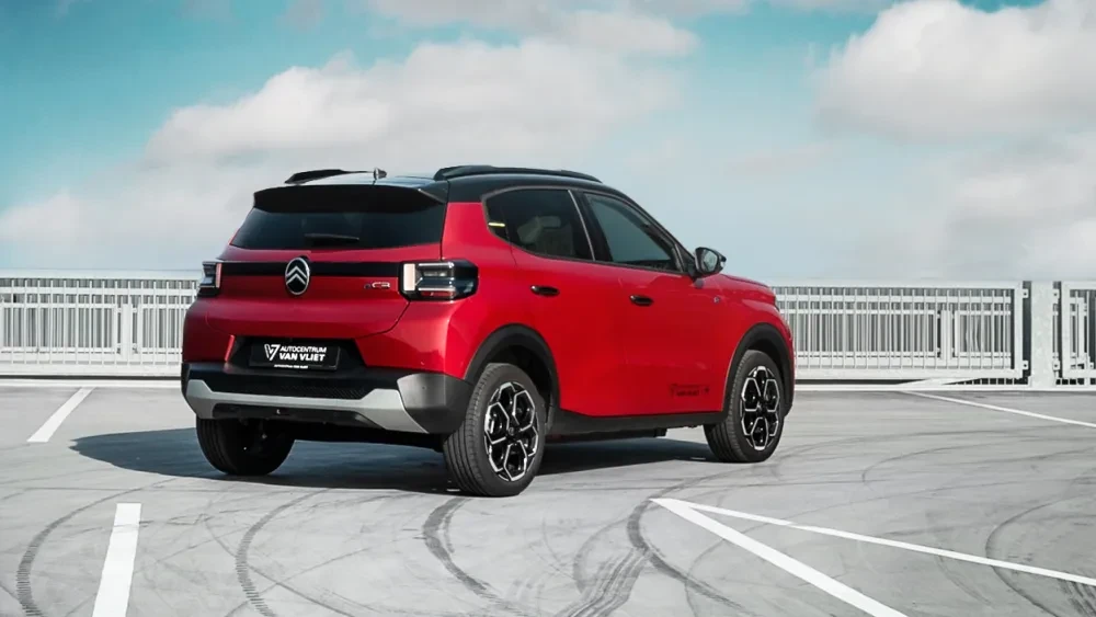 Een rode Citroën EC3 staat geparkeerd in een parkeergarage, met de glanzende carrosserie goed zichtbaar.