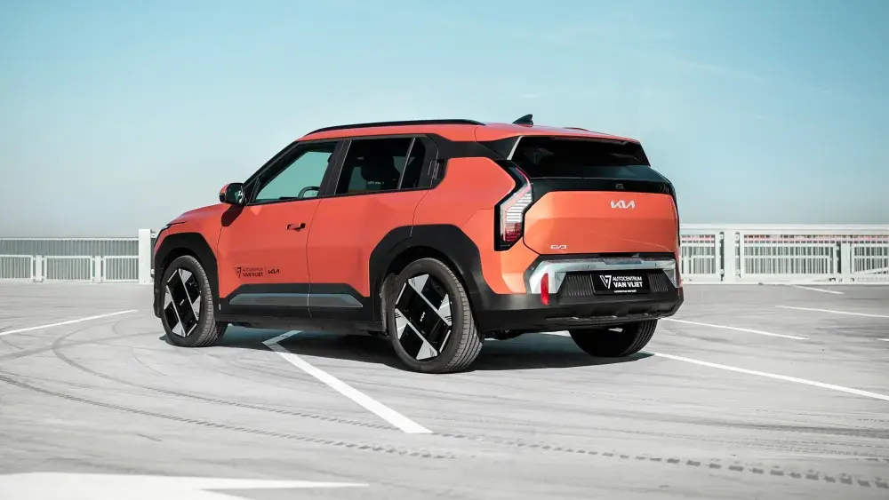 Oranje Kia EV3 op een parkeerterrein.