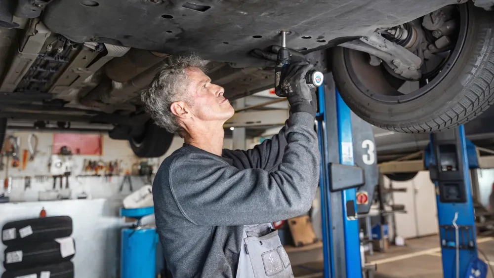 Monteur voert onderhoud uit aan een Citroën bij Autocentrum Van Vliet met originele onderdelen.