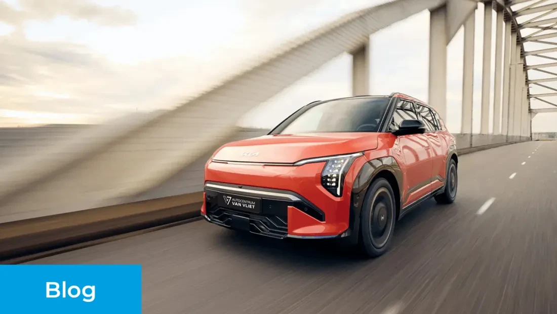 Rode elektrische Kia EV3 rijdt op de openbare weg. De auto bevat een kentekenplaat met daarop 'Autocentrum Van Vliet'